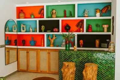 a room with shelves filled with different colored vases at Villa - Piscine chauffée sur demande et gouvernante in Marrakech