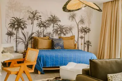 a bedroom with a bed with palm trees on the wall at Villa - Piscine chauffée sur demande et gouvernante in Marrakech