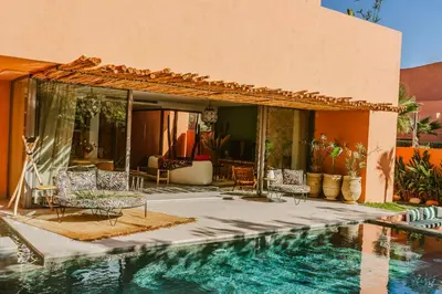 a house with a swimming pool next to a house at Villa - Piscine chauffée sur demande et gouvernante in Marrakech