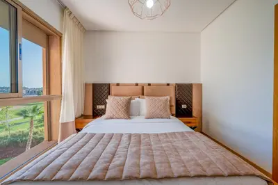 a bedroom with a large bed with a large window at Luxury and serenity in Prestigia Golf & Pool in Marrakech