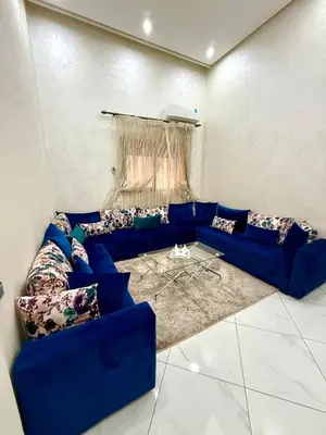 a living room with a blue couch with pillows at Appartement sympathique in Marrakech
