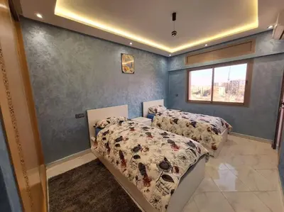 a bedroom with two beds and a window at Jardin Majorel Appartement en résidence fermée in Marrakech
