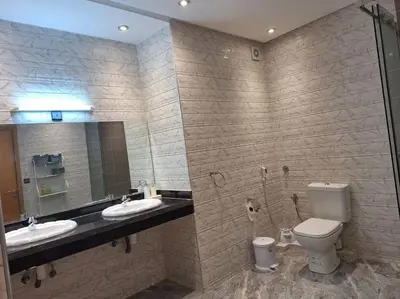 a bathroom with two sinks and a toilet and a mirror at Jardin Majorel Appartement en résidence fermée in Marrakech