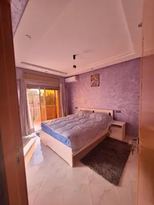 a bedroom with a large bed and a window at Jardin Majorel Appartement en résidence fermée in Marrakech