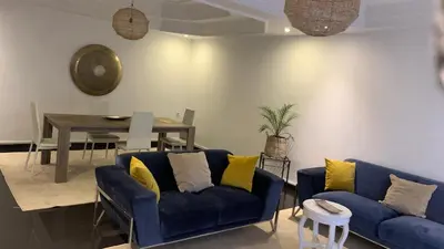 a living room with a blue couch and a table at Appartement au cœur de Marrakech in Marrakech