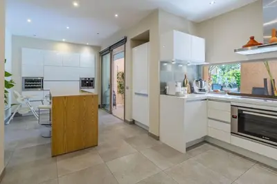 a kitchen with white cabinets and a counter top at Villa sur golf avec piscine privée chauffée in Marrakech