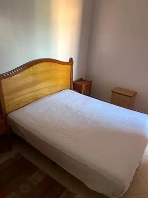 a bedroom with a white bed with two tables at Appartement Cosy & Calme à Izdihar Confort Assuré in Marrakech