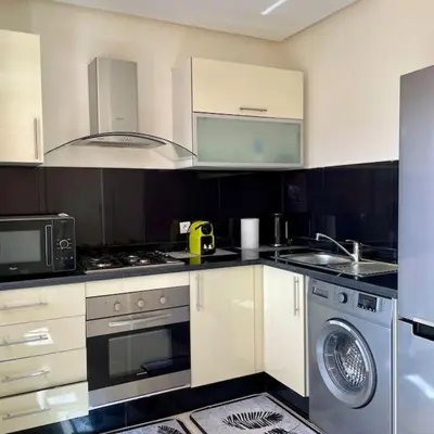 a kitchen with a stove and a sink and a washer at Appartement Centre Gare gueliz chic et cosy de Marrakech in Marrakech