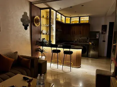 a living room with a couch and a kitchen at Appartement confort in Marrakech