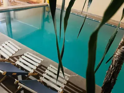 a table and chairs next to a swimming pool at Apart Hotel Larabi in Marrakech
