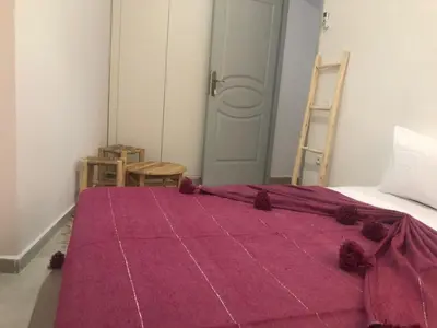 a bedroom with a bed with a pink blanket on it at Riad Nomad House Marrakech in Marrakech