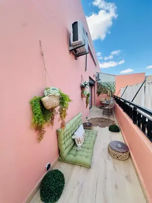 a green couch sitting on the side of a pink building at Magnifique 1 Room WIFI en plein coeur de GUELIZ in Marrakech