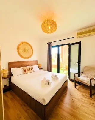 a bedroom with a bed and a large window at Magnifique 2 chambres Terrasse et Wifi à Marrakech in Marrakech