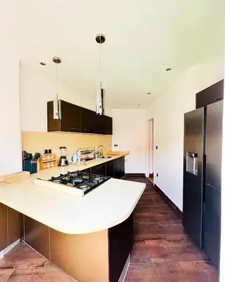 a kitchen with a white counter and a black refrigerator at Magnifique 2 chambres Terrasse et Wifi à Marrakech in Marrakech