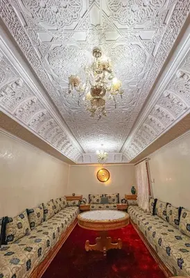 a living room with a couch and a chandelier at Superbe Appartement en Résidence, Marrakech Guiliz in Marrakech