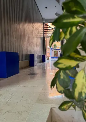 a lobby with a plant in the middle of a room at Superbe Appartement en Résidence, Marrakech Guiliz in Marrakech