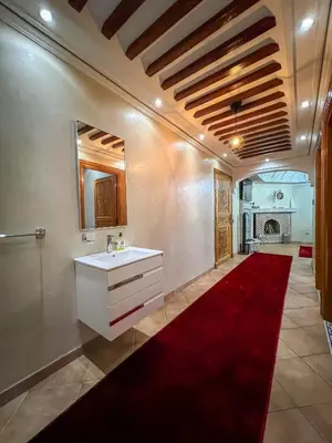 a bathroom with a sink and a red carpet at Superbe Appartement en Résidence, Marrakech Guiliz in Marrakech