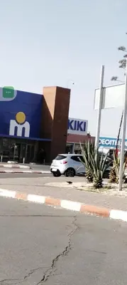 a car parked in a parking lot in front of a store at Cozy Apartment in Hay Charaf district, Marrakech in Marrakech