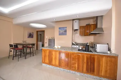 a kitchen with a wooden counter top and a table at Cozy Apartment in Hay Charaf district, Marrakech in Marrakech