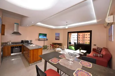 a kitchen and living room with a table and chairs at Cozy Apartment in Hay Charaf district, Marrakech in Marrakech