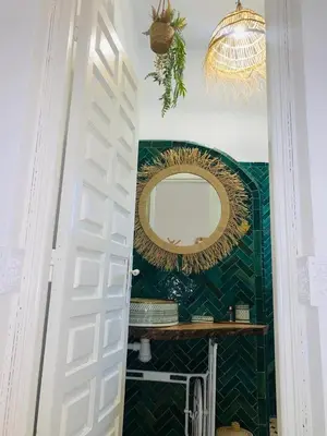 a bathroom with a mirror on the wall and a door at Riad Kechin Beldi in Marrakech