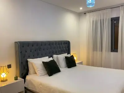 a bedroom with a large bed with two black pillows at MARRAKECH Palmeraie Gates in Marrakech