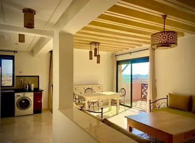 a living room with a table and a kitchen at cozy appartement in Marrakech