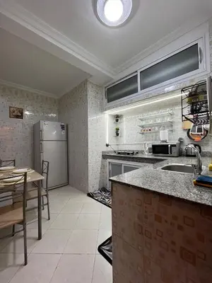 a kitchen with a stainless steel refrigerator and a table at Cozy Apartment Near Airport in Marrakech