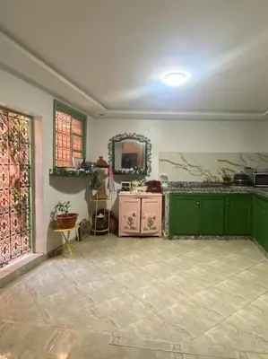a large kitchen with green cabinets and a mirror at La porte d Or in Marrakech