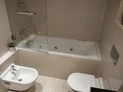 a bathroom with a toilet and a tub and a sink at Prestigia appartement in Marrakech