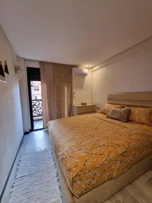 a bedroom with a large bed with an orange blanket at Shine house in Marrakech