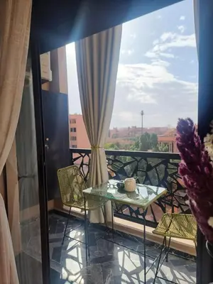 a balcony with a table and chairs and a window at Shine house in Marrakech