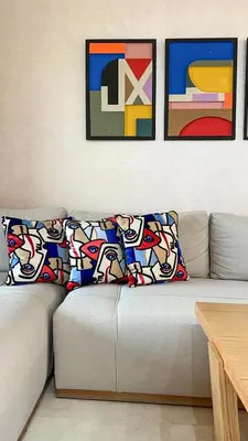 a living room with a couch with three pictures on the wall at Appartement Marrakech prestigia by Sofia 2 chambres piscine in Marrakech