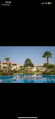 a picture of a pool with palm trees in it at Appartement Marrakech prestigia by Sofia 2 chambres piscine in Marrakech