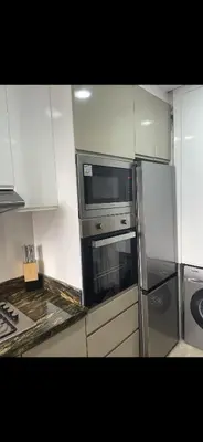 a kitchen with a stainless steel refrigerator and a microwave at Appartement Marrakech prestigia by Sofia 2 chambres piscine in Marrakech