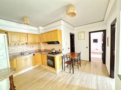 a kitchen with yellow cabinets and a wooden table at Appart cozy hyper centre calme in Marrakech