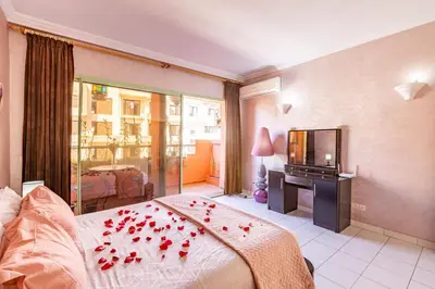 a bedroom with a bed with red roses on it at Appartement Duplex confort qualité très bien situé in Marrakech