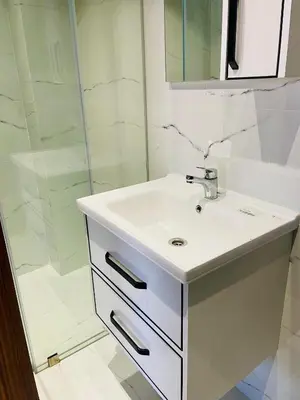 a white bathroom with a sink and a shower at Nomad's Cosy Apartment Gueliz Center in Marrakech