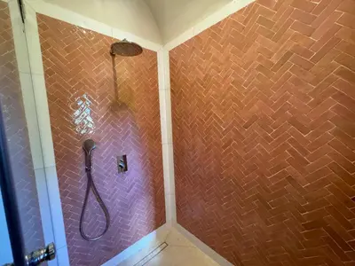 a bathroom with a shower with a brick wall at Villa Ania in Marrakech