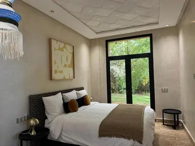 a bedroom with a large bed and a large window at Villa Ania in Marrakech