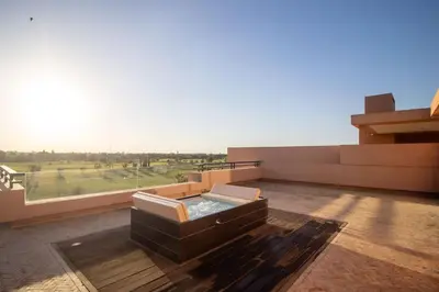 a balcony with a hot tub on top of a building at HM50 l Villa en front de golf piscine & jacuzzi in Marrakech