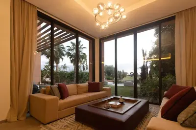 a living room with a couch and a large window at HM50 l Villa en front de golf piscine & jacuzzi in Marrakech