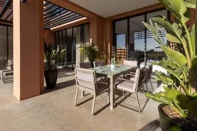 a dining room with a glass table and chairs at HM50 l Villa en front de golf piscine & jacuzzi in Marrakech