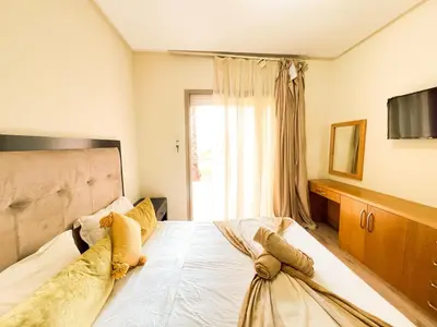 a bedroom with a large bed and a window at Serene Stay Cozy Flat in Marrakech in Marrakech