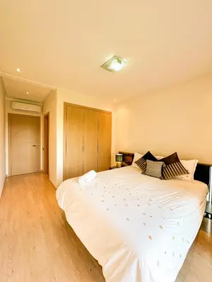 a large white bed in a room with wooden floors at Serene Stay Cozy Flat in Marrakech in Marrakech