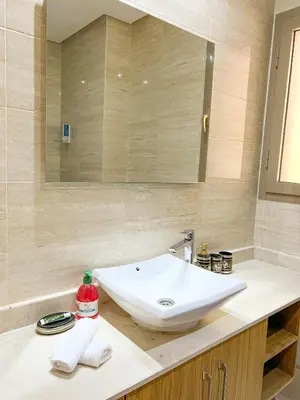 a bathroom with a white sink and a mirror at Serene Stay Cozy Flat in Marrakech in Marrakech