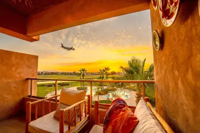 a view from a balcony with an airplane taking off at Serene Stay Cozy Flat in Marrakech in Marrakech