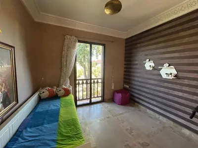 a room with a colorful couch in a room with a window at appart jardin de l atlas Marrakech Waky Beach Golf Montagne de l Atlas in Marrakech