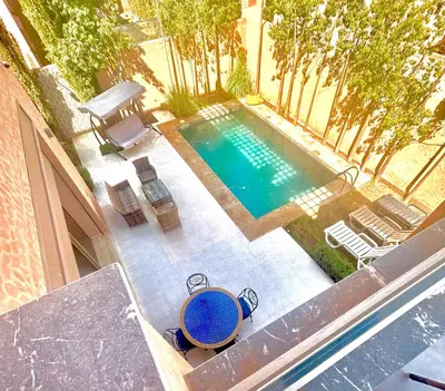 an overhead view of a swimming pool with a table and chairs at Villa à marrakech avec piscine in Marrakech