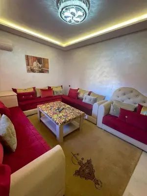 a living room with couches and a table at Appartement bien équipé in Marrakech